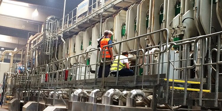 Film ab in Neustadt Man sieht 3 Personen vor einer großen Maschine in einer Produktionsstätte
