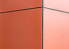 Close-up of an orange façade with rivets