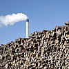 A stack of long wood, behind which the CHP fireplace at the Neumarkt site can be seen.
