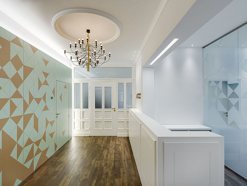 The reception area in the dental practice of Dr. Viehmann A bright and modern reception area in the dental practice of Dr. Viehmann, with white furniture and also a digital printing partition wall made of products from Pfleiderer.