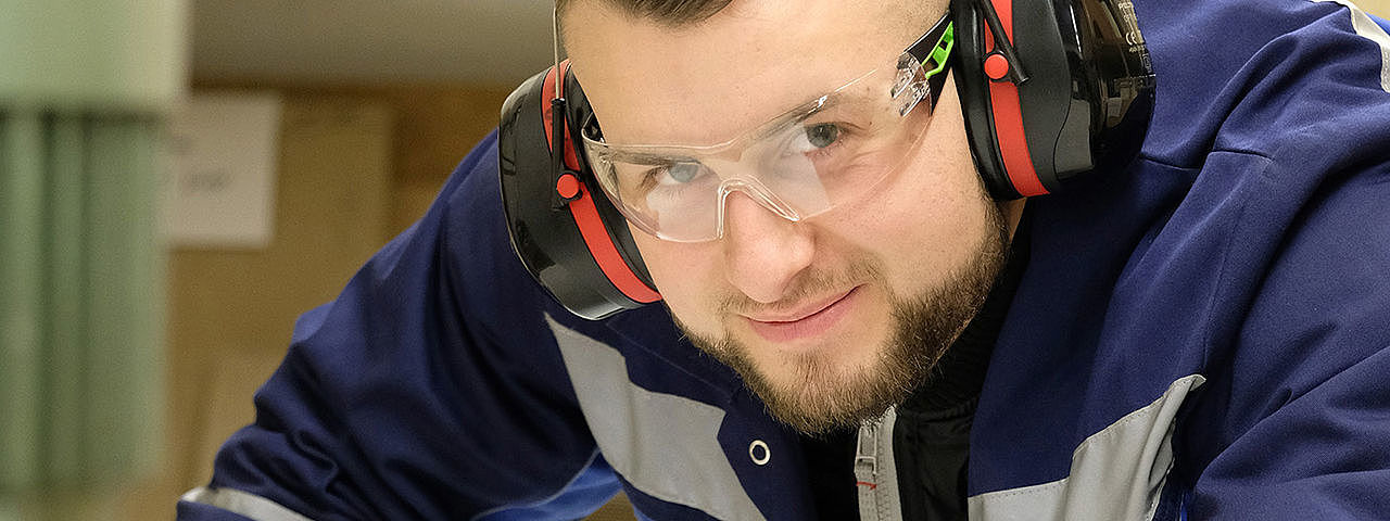 Symbolbild Anlagenführer Ein Mann in Schutzkleidung bedient große Maschinen