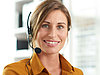 A nice ladies smiling into the camera with a headset on her ear.