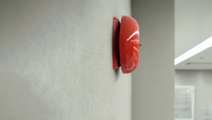 Rote Feueralarm-Glocke an einer Flurwand