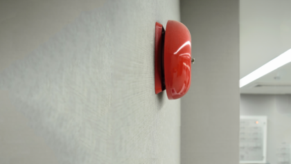 Rote Feueralarm-Glocke an einer Flurwand