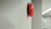 Rote Feueralarm-Glocke an einer Flurwand
