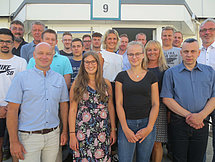 Gruppenbild Auszubildende Arnsberg Man sieht etwa 20 Auszubildende und Ausbildende, welche in vier Reihen für ein Gruppenbild posieren