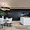 An open-plan kitchen-living room with a black back wall that can be hidden behind a sliding door. In front of it is a white dining set.