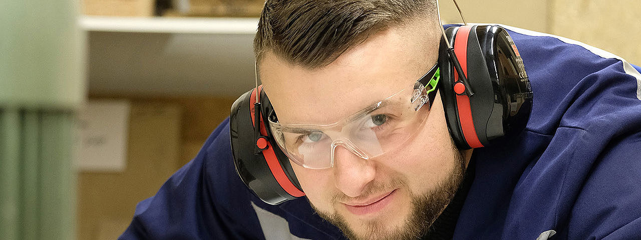 Ein Mann in Schutzkleidung, der schwere Maschinen bedient