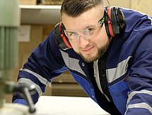 Ein Mann in Schutzkleidung, der schwere Maschinen bedient