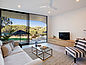Moderní relaxační prostor se širokými okny, pohovkou, TV a příborníkem z produktů Pfleiderer.