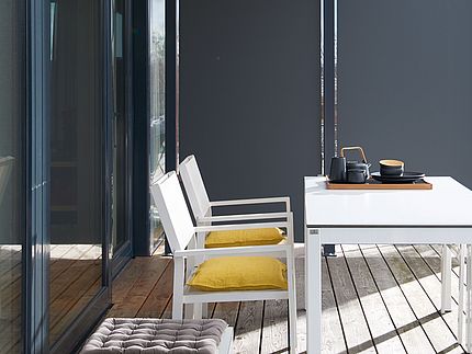 Mobili da esterno Una terrazza soleggiata con mobili da esterno e una parete divisoria in Compact XTerior.