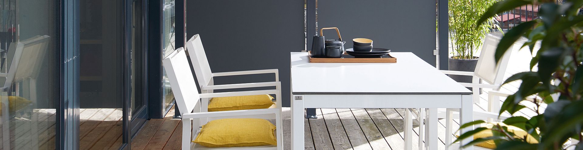 Outdoor furniture A sunny terrace with outdoor furniture and a partition wall made of Compact XTerior.