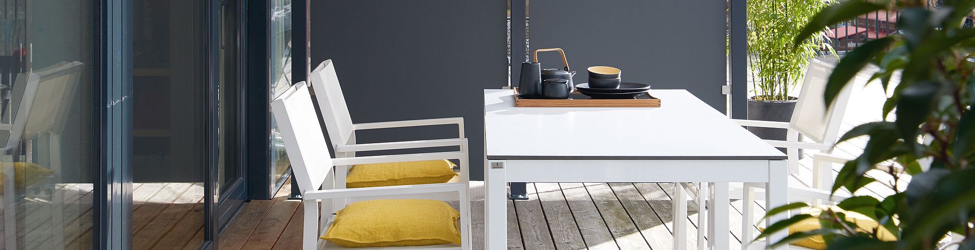 Outdoor furniture A sunny terrace with outdoor furniture and a partition wall made of Compact XTerior.