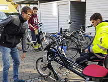 Auszubildende an Fahrrädern Zu sehen sind 4 Auszubildende, welche zwischen Garagen an Fahrrädern basteln