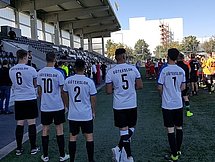 Fußballspieler Toennies Cup Fünf Fußballspieler stehen am Rand eines Sportplatzes vor einer Tribüne. Man sieht sie von hinten. Auf ihren Trikots steht "Gütersloh".