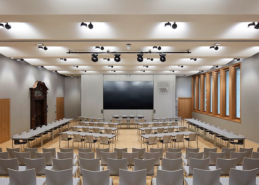 New Town Hall Bernau Office The photo shows the great hall of the new town hall. It features a big screen, light materials and some wooden elements.