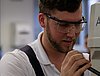 A young man in protective gear operates a small machine