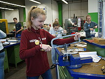 Girls Day Metallsäge Man sieht eine junge Dame, welche eine Metallsäge verwendet.
