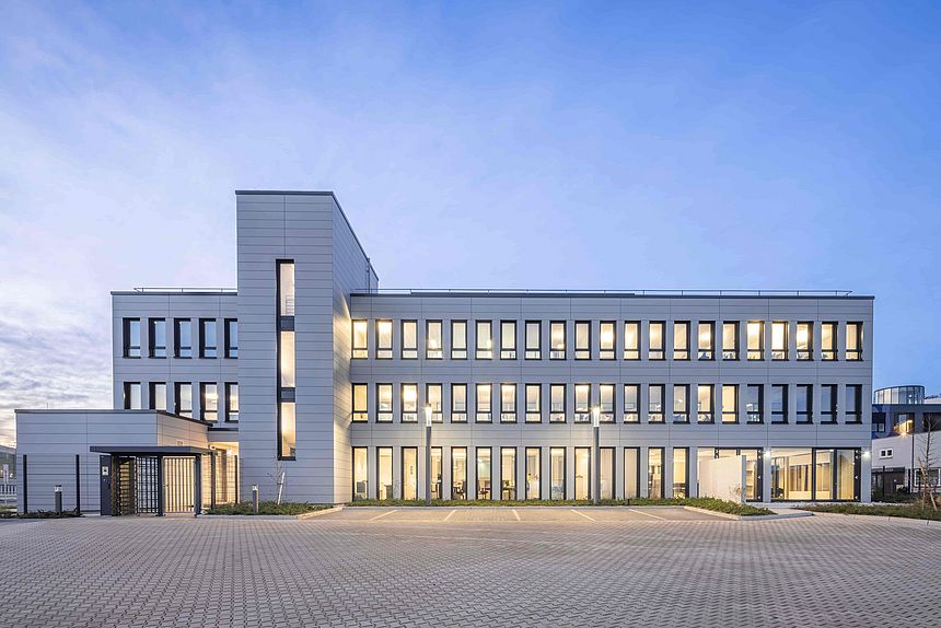 Office building with a gray façade and illuminated windows