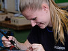 A young woman carefully working on a circuit board