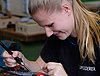 A young woman carefully working on a circuit board