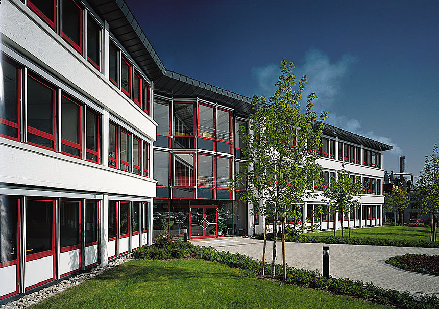 The administration building at the Leutkirch site The façade of the Pfleiderer administration building at Standot Leutkirch, with large windows with red frames.