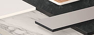 Stapel unterschiedlicher Kompaktplatten mit schwarzem, weißem und grauem Kern