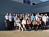 Mehrere potenzielle Auszubildende posieren für ein Gruppenfoto vor einem Werkstattgebäude.