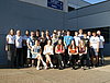 Mehrere potenzielle Auszubildende posieren für ein Gruppenfoto vor einem Werkstattgebäude.