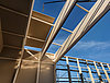 The construction of the warehouse Nützeln, in which a slab is being lifted onto the roof by crane.