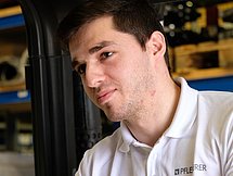 Das Bild zeigt einen Mann, der einen Gabelstapler fährt