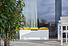 A white bench on a terrace with yellow cushions, made of XTerior compact.