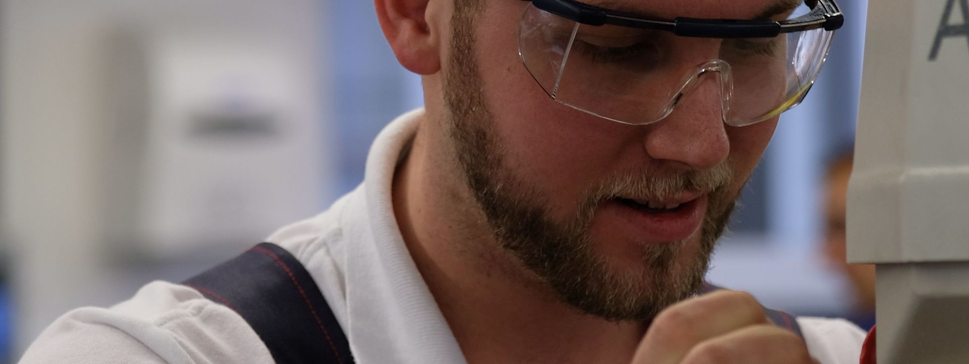 Symbolbild Industriemechaniker Das Bild zeigt einen Mann in Schutzkleidung bei der Handhabung einer Maschine