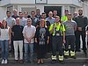 Eine Gruppe von etwa 20 Auszubildenden und Ausbildern posiert vor einem Gebäude für ein Gruppenfoto