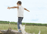 Here you will find all information on Pfleiderer's corporate responsibility with regard to quality philosophy, occupational safety, energy management, the environment and sustainability. A boy can be seen from behind, balancing on a tree trunk in nature.