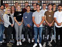 Ausbildungsstartgruppenfoto Gütersloh Man sieht etwa 20 Auszubildende und Ausbilder, welche in 3 Reihen für ein Gruppenfoto posieren.