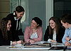 The picture shows a group of young graduates and employees at a table together with a specialist from Pfleiderer. Some documents about Pfleiderer are lying in front of the persons.