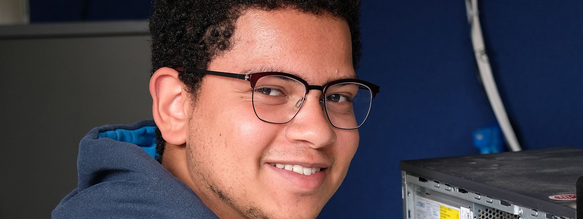 Symbolbild Informatiker Ein junger Mann repariert einen PC