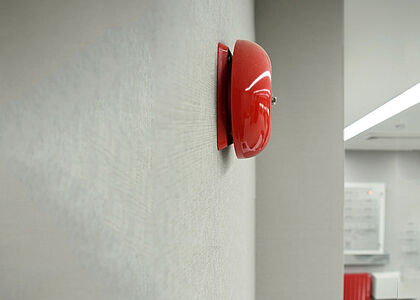 Fire bell on grey fire resistant wall cladding Fire bell on grey fire resistant wall cladding