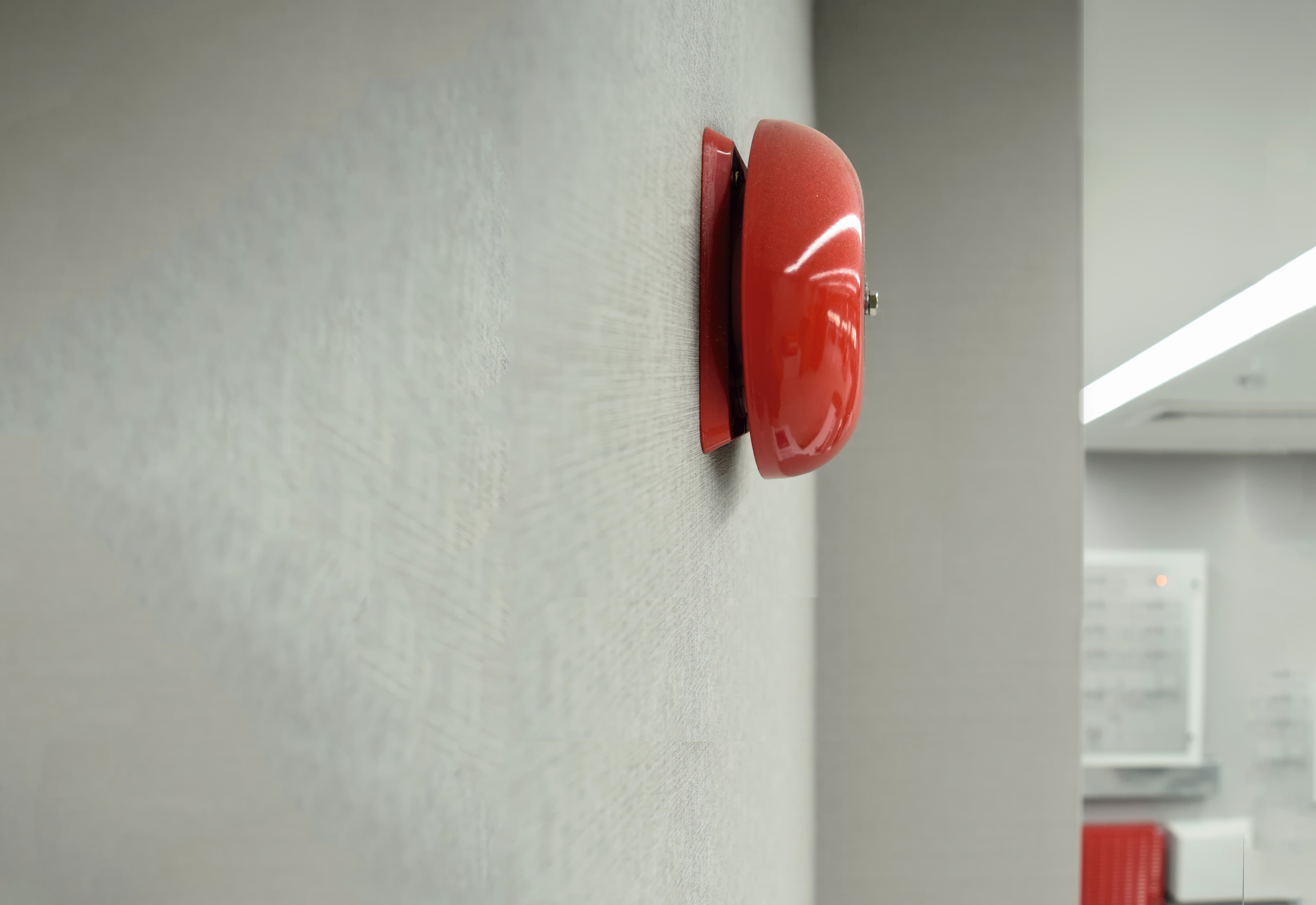 Rote Feueralarm-Glocke an einer Flurwand